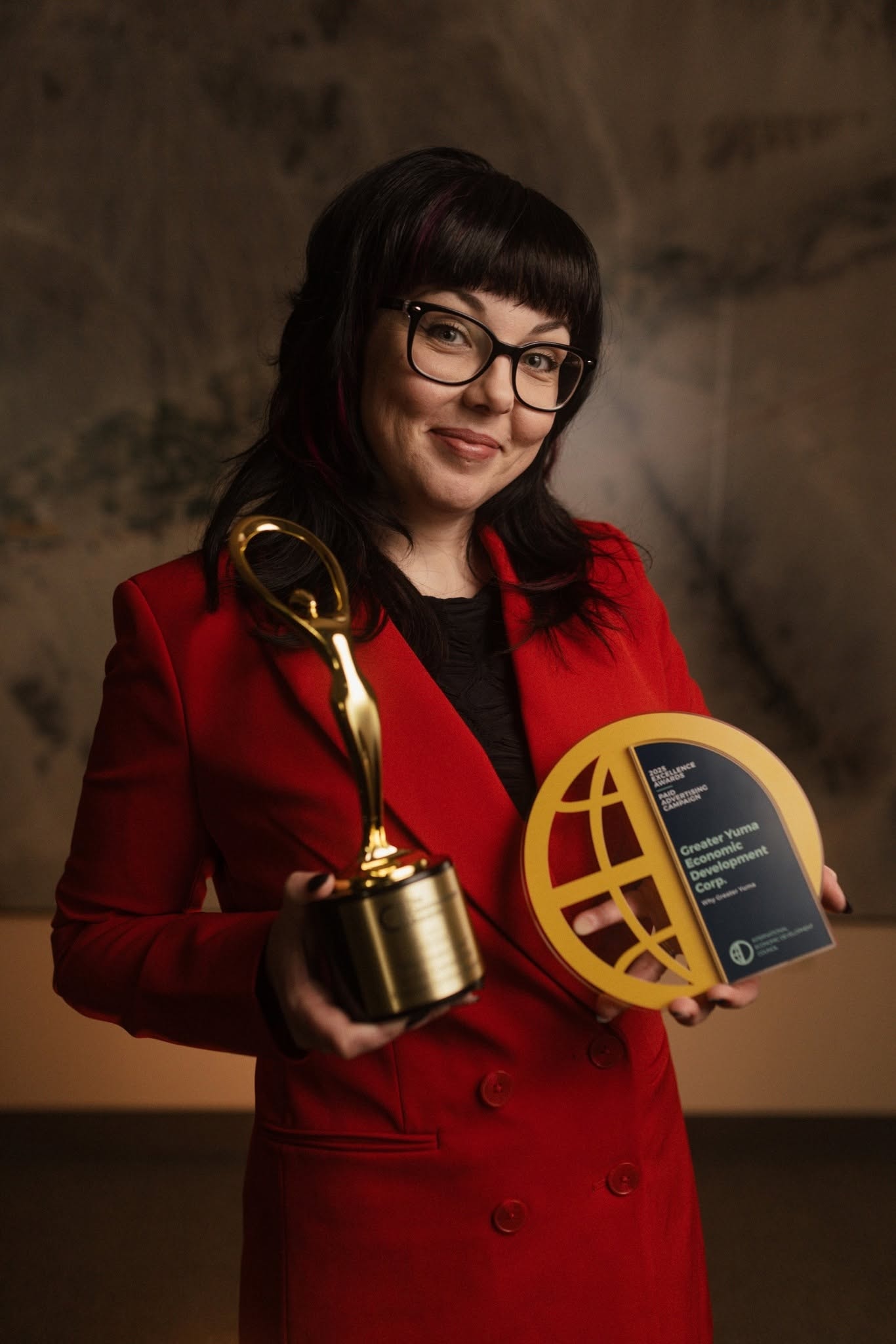 Lyndsay Wisneski, founder of Riveting Creative, holding advertising awards